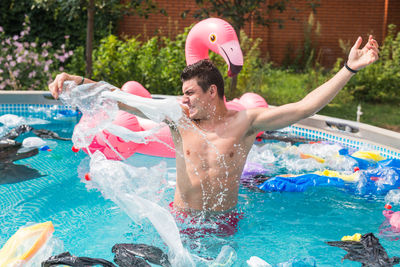 Full length of shirtless man in swimming pool