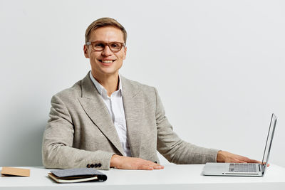 Portrait of businessman standing against white background