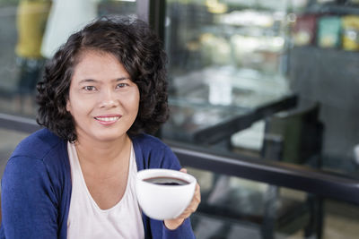 Portrait of smiling woman with coffee cup