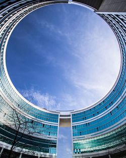 Low angle view of modern building against cloudy sky