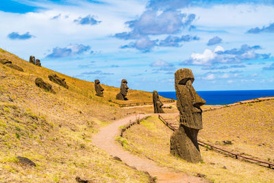 Stone sculptures on landscape against sky