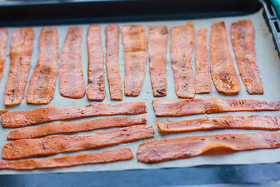 Sliced carrots are lying on parchment paper on a protvin for cooking carrot bacon. vegetarian food