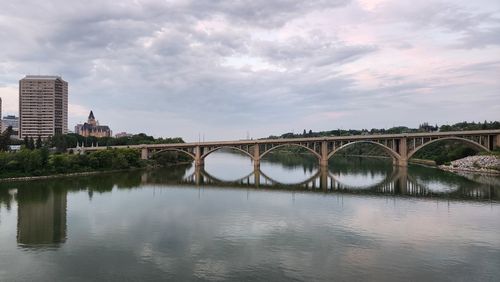 Bridge over river against cloudy sky