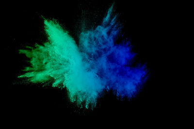 Defocused image of multi colored powder paints against black background