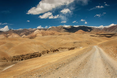 Scenic view of desert road against sky