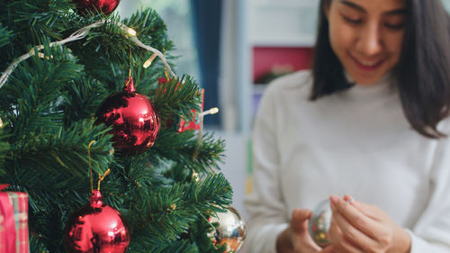 Midsection of woman holding christmas tree