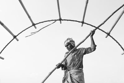 Low angle view of man standing against clear sky