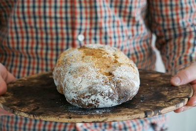 Close-up of hand holding homemade sourdough bread