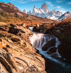 Scenic view of waterfall against sky