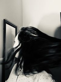 Portrait of young woman against wall at home