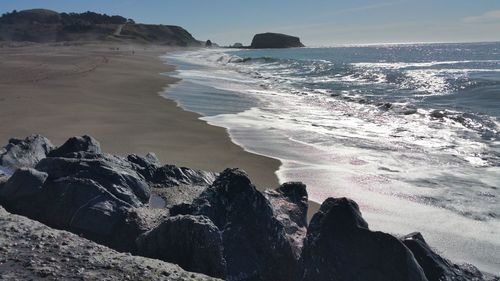 Scenic view of sea against sky and pattern in the sand.