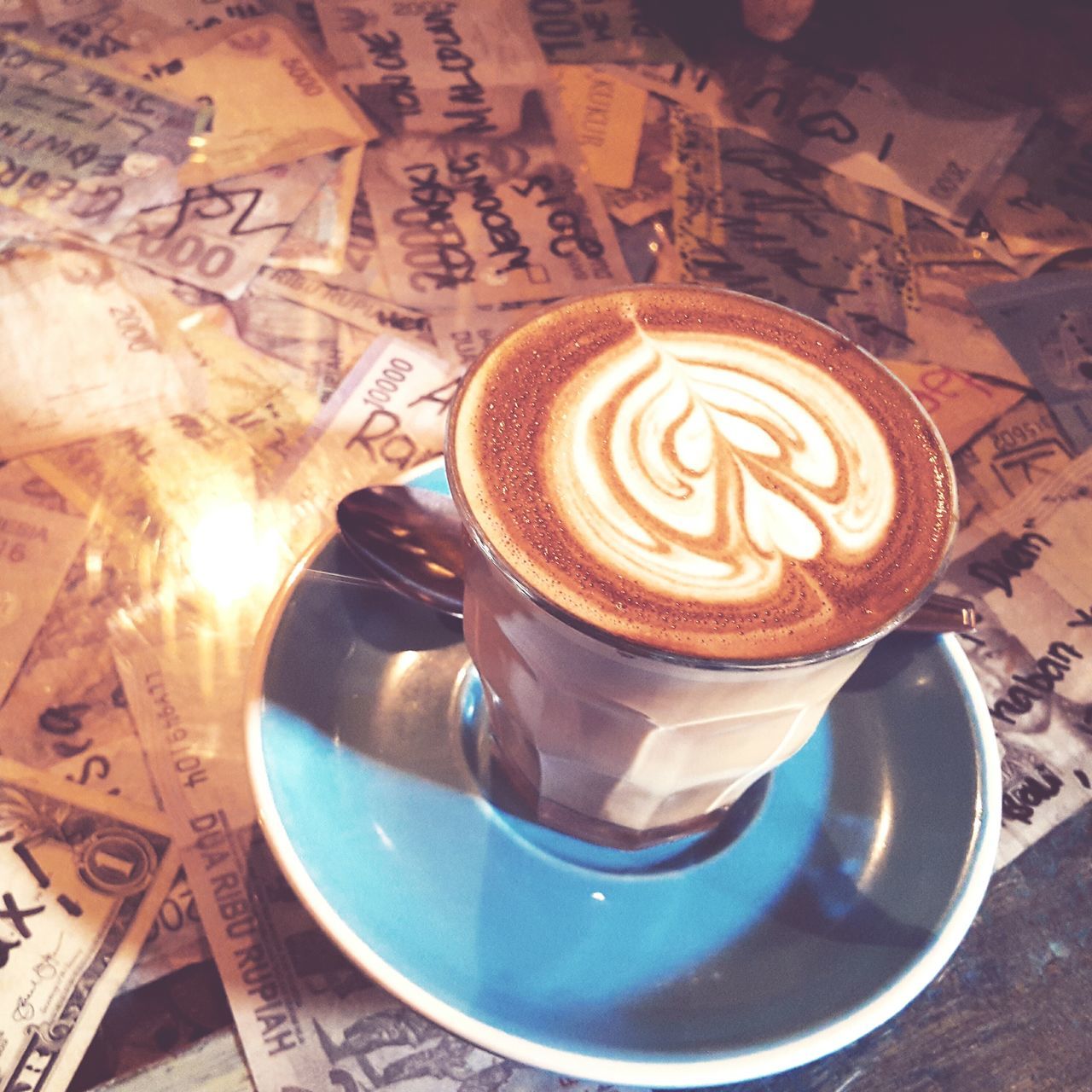 drink, refreshment, indoors, coffee cup, froth art, frothy drink, coffee - drink, saucer, food and drink, cappuccino, table, close-up, freshness, high angle view, art, creativity, latte, still life, art and craft, heart shape