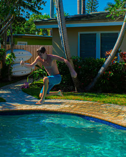 Young boy jumping in swimming pool