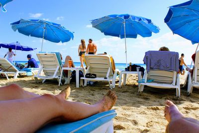 Low section of people relaxing on beach