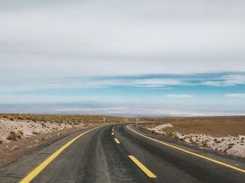 Road passing through landscape against sky