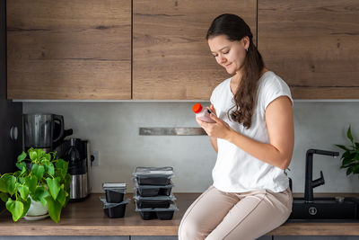 Side view of young woman using mobile phone