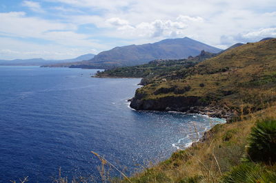 Scenic view of sea and mountains against sky