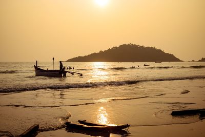 Silhouette people on boat in sea against clear sky