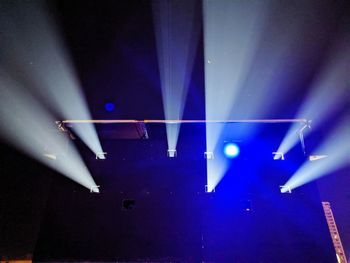 Low angle view of illuminated lighting equipment at night