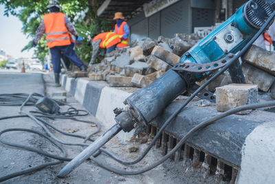 Close-up of construction machinery against workers on street