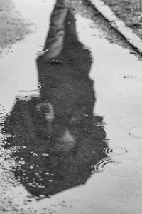 Low section of person in puddle on wet street