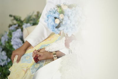 Midsection of mother and daughter against white wall