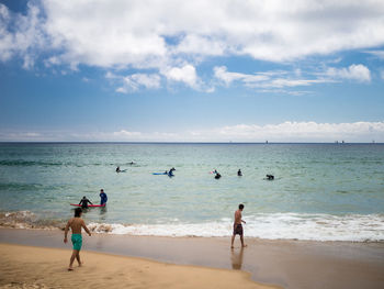 People on beach against sky