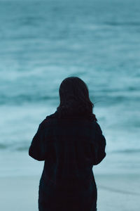 Rear view of woman standing at beach