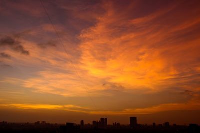 Scenic view of cloudy sky during sunset over city