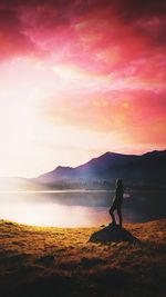 Woman standing on beach against sky during sunset