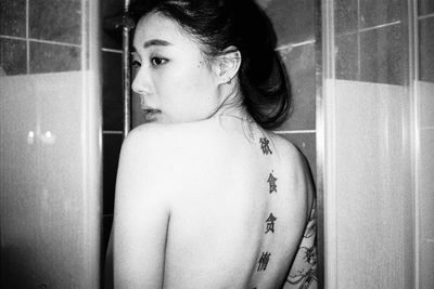 Close-up of woman with chinese tattoos