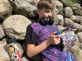 Full length of boy photographing on rock