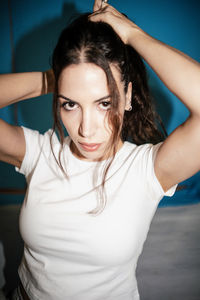 Portrait of young woman with arms raised