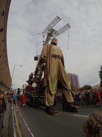 Rear view of people on road against sky in city