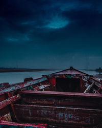 Abandoned boats moored on sea against blue sky