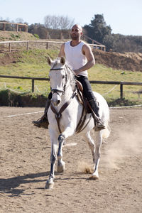 Full length of man sitting on horse against sky