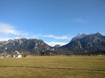 Scenic view of field and mountains against sky