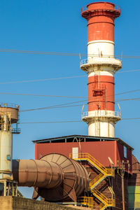 Low angle view of industry against blue sky