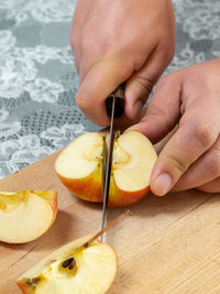 Close-up of hand holding ice cream on cutting board