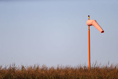 Wind turbines on field against clear sky