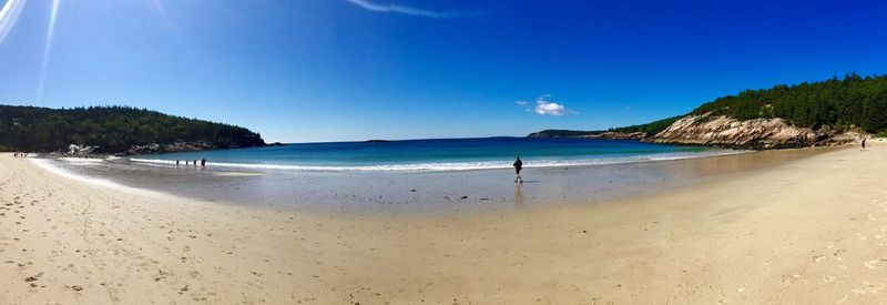 Scenic view of beach against clear blue sky