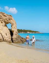 Rear view of woman standing at beach