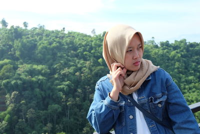 Side view of woman standing against mountain