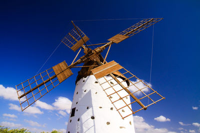 Low angle view of traditional windmill against sky