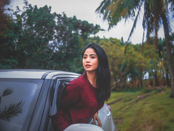 Portrait of beautiful young woman in car