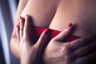 Midsection of woman with hands on breast