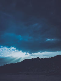 Scenic view of mountain against dramatic sky