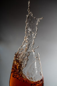 Close-up of water drops on glass against white background