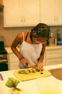 Midsection of woman chopping food on a table