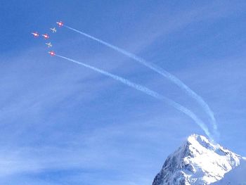 Low angle view of snowcapped mountain against blue sky